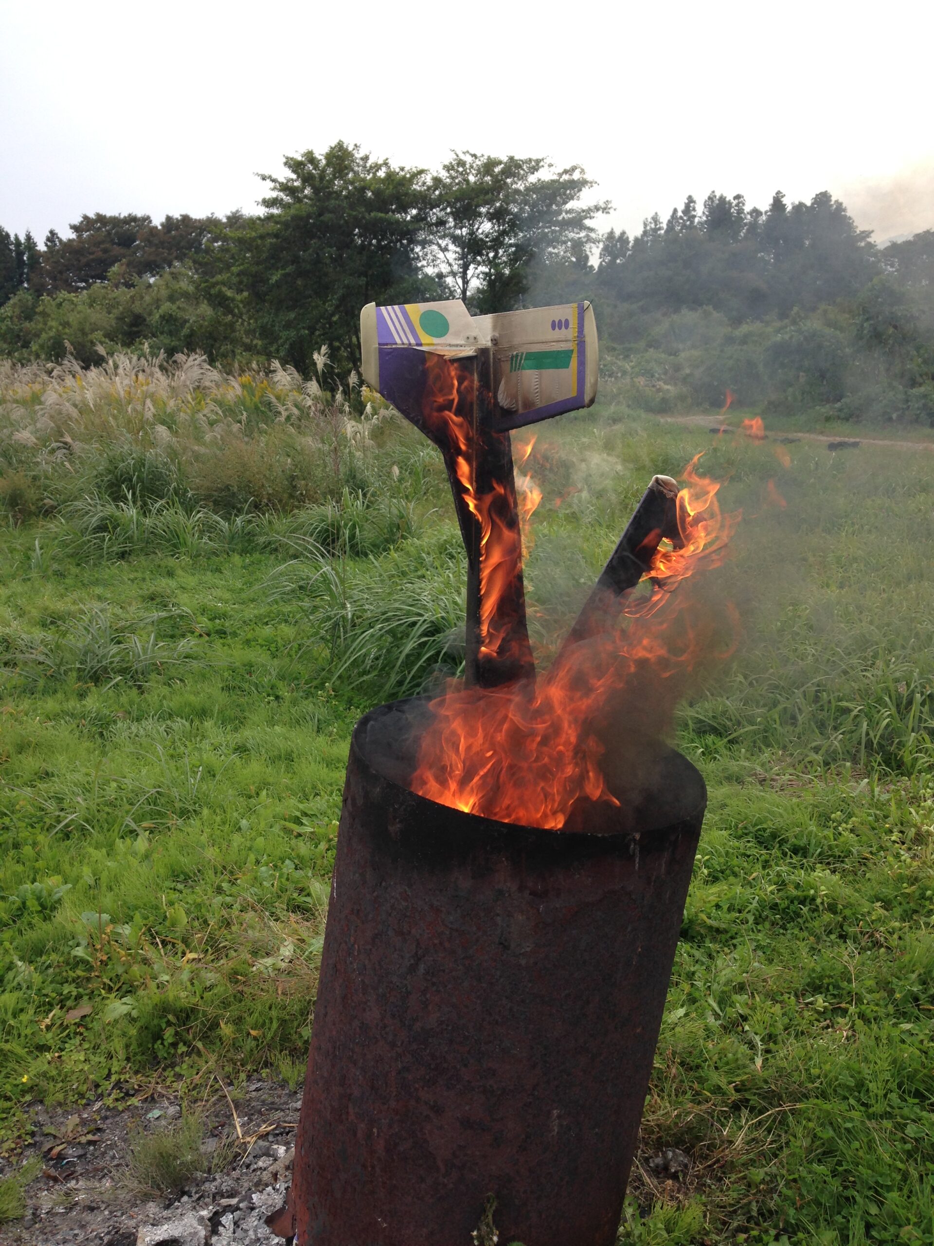 焼却炉の炎に包まれるラジコン機。フィルムを張った尾翼が立っている
