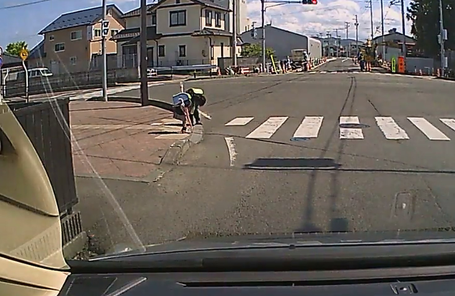 渡り終えた横断歩道に向かって深く頭を下げる、ランドセルを背負った小学生二人。ドライブレコーダーの映像