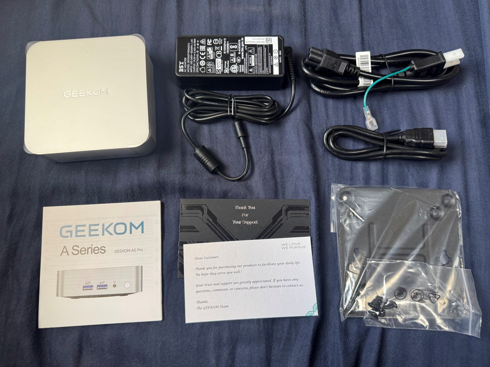ミニパソコン本体、ACアダプタ、電源ケーブル、HDMIケーブル、説明書、VESAマウンタとネジが並べられた写真