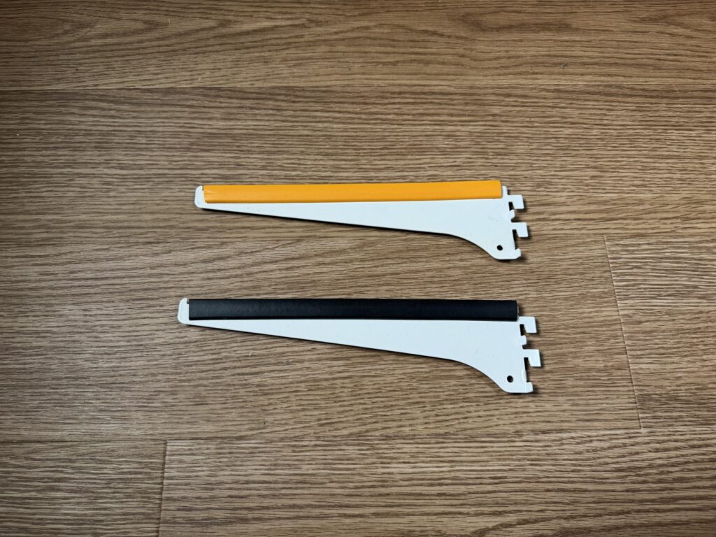 上の辺にオレンジと黒のゴムをかぶせた棚受2本